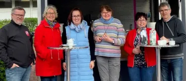 6 Personen vor Stand